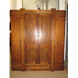 An early 20th Century continental triple wardrobe with double doors flanked either side by curved