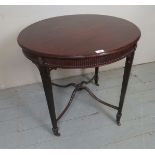 A detailed Edwardian mahogany round lamp table with a carved frieze and legs with castors, 29.