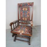 An Edwardian mahogany rocking armchair upholstered in a tapestry style material est: £150-£250