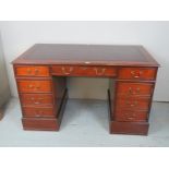 A Georgian design mahogany pedestal desk with a brown tooled leather top and cable hole to rear,