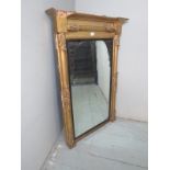 A 19th Century gilt wall mirror with bevelled edge glass and carved spandrels,