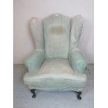 An early - mid 20th Century winged armchair terminating on cabriole legs est: £50-£80
