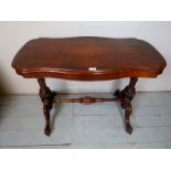 A Victorian walnut table with end columns,