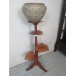 An Edwardian walnut plant stand with four carved acorn leaf shelves and a brass jardiniere est: