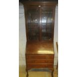 A 20th century mahogany bureau bookcase with double glazed doors over a fall front flap revealing a