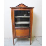 An Edwardian inlaid and banded mahogany music cabinet with a single glazed bow door over tapering