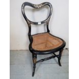 A Victorian ebonised and mother of pearl inlaid chair with a cane seat est: £20-£30