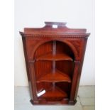 A 20th Century wall hanging mahogany corner cabinet with two open shaped shelves and in good