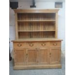 A fine 19th Century pitch pine dresser with open shelves above four short drawers and cupboards