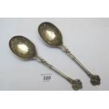 A pair of ornately decorated silver spoo