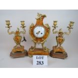 A clock garniture in striking orange mar