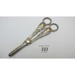 A pair of silver grape scissors with emb