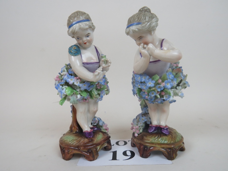 A pair of late 19th/early 20th century German flower-encrusted porcelain figures, 17 cm high,