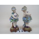 A pair of late 19th/early 20th century German flower-encrusted porcelain figures, 17 cm high,