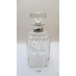 A heavy cut glass decanter with silver c