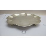 A silver flower shaped salver on ball fe