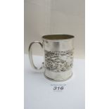 A silver embossed Christening mug decora