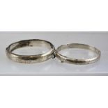 TWO SILVER BANGLES each of hinged form with acanthus leaf engraved decoration