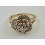 A 9CT GOLD DIAMOND ROSE CLUSTER HEADED DRESS RING, having central diamond surrounded by three