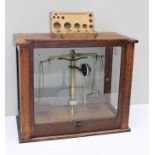 A SET OF BRASS SCIENTIFIC BALANCE SCALES cased 51.5cm wide and a wooden BOX OF WEIGHTS