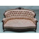 A VICTORIAN MAHOGANY CARVED SHOW FRAME TWO-SEATER SOFA with carved scallop crest, upholstered shaped