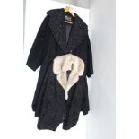 A DEBENHAM & FREEBODY OF LONDON BLACK WOOL LADY'S COAT with Persian lamb shawl collar and a lady's