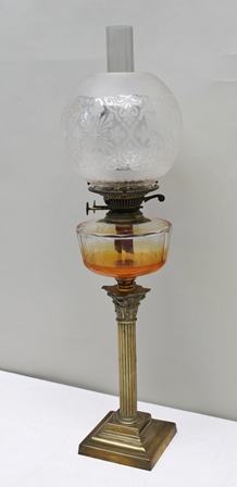 A LATE VICTORIAN BRASS CORINTHIAN COLUMN OIL LAMP with clear glass reservoir and decorative etched