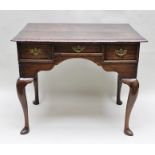 A GEORGE III OAK LOWBOY SIDE TABLE fitted three drawers with brass handles, raised on cabriole