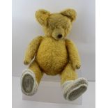 AN EARLY TO MID 20TH CENTURY TEDDY BEAR, having golden mohair plush with stitched paws and nose,