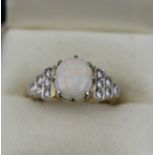 A LADY'S OPAL SET RING, the shoulders diamond set in rows of three, two and one (six on either