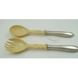 A PAIR OF IVORY EFFECT SALAD SERVERS, comprising spoon and fork with white metal handles