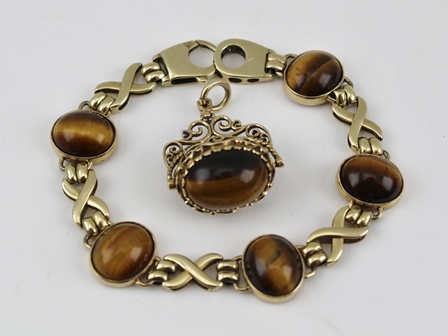 A 9CT GOLD BRACELET set with polished Tiger's Eye stones, together with a PENDANT/FOB set Tiger's