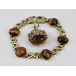 A 9CT GOLD BRACELET set with polished Tiger's Eye stones, together with a PENDANT/FOB set Tiger's