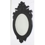 A VENETIAN DESIGN DECORATIVE BLACK GLASS FRAMED WALL MIRROR inset with oval bevel-plate, overall