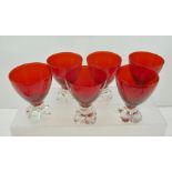 A SET OF SIX MURANO WINE GLASSES, having ruby red bowls on clear quatrefoil lobed bases, circa 1949,