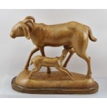 A 20TH CENTURY CARVED HARDWOOD MODEL OF AN ASIAN GOAT together with her kid, on a base, 23cm high