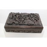 A LATE 19TH CENTURY BLACK FOREST BOX, the hinged cover carved with fruiting vine, 28cm wide (with