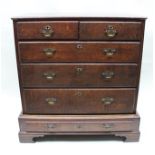 A GEORGE III OAK CHEST OF TWO SHORT OVER THREE LONG DRAWERS, raised on a base fitted one long drawer