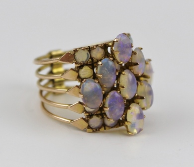A LADY'S DRESS RING, comprising five hinged sections of yellow metal, set with opals, size O