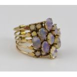 A LADY'S DRESS RING, comprising five hinged sections of yellow metal, set with opals, size O