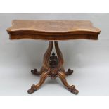 A VICTORIAN WALNUT VENEER FOLD-OVER CARD TABLE, having serpentine front on decorative stem and