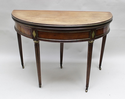 A 19TH CENTURY CENTURY MAHOGANY DEMI-LUNE FOLDOVER CARD TABLE having brass inlay decoration,