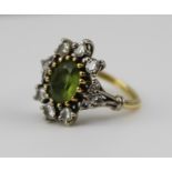 A LADY'S RING, having a central pale green stone, possibly a citrine, surrounded by diamonds, on a