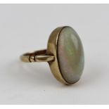 A POLISHED OVAL OPAL SET RING in a rub over 9ct gold mount, ring size K and half