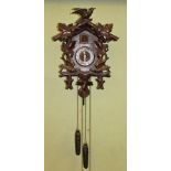 A BLACK FOREST WALL MOUNTING CUCKOO CLOCK, the carved wooden case with automaton movement, Gothic