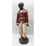 A LIFE-SIZE POLYCHROME PAINTED PLASTER BLACKAMOOR, a boy dressed in ragged jacket and stripe