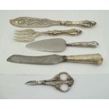 A SILVER HANDLED CARVING KNIFE, London 1893, silver handled GRAPE SCISSORS, a silver handled CAKE