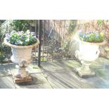 A PAIR OF CAST IRON CAMPANA SHAPED GARDEN URNS with loop handles, on square plinth bases, 77cm