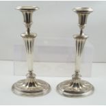 A PAIR OF SILVER PLATED CANDLESTICKS of Classical Adam design, on oval weighted bases, complete with