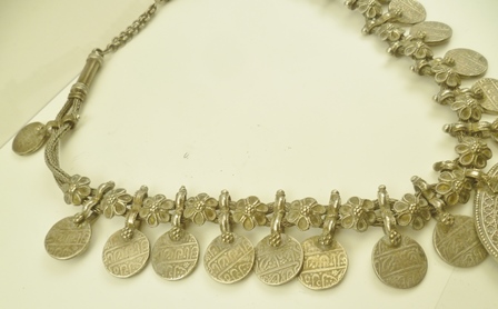 A BEDOUIN WHITE METAL NECKLACE decorated with coins, alternating with flower heads, suspending a - Image 4 of 5